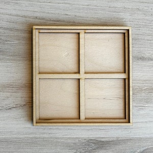 May include: A wooden tray with four square compartments. The tray is made of light brown wood and has a natural finish.