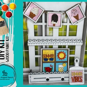May include: A DIY wood paint kit featuring a summer theme. The kit includes a variety of wooden shapes, including ice cream cones, a sun, sunglasses, a watermelon slice, a glass of lemonade, and a sign that says "Summer Vibes".