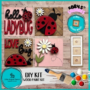 May include: DIY wood paint kit featuring four 4.5 inch square wooden signs with ladybug and flower designs. The signs include the text "hello ladybug", "love bug", and a ladybug on a flower. The kit includes paint and a paintbrush.
