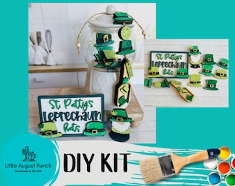 May include: DIY kit for making St. Patty's Leprechaun hats. The kit includes wooden cutouts of hats, leprechauns, and a sign that says "St. Patty's Leprechaun Hats". The kit also includes paint and a paintbrush.