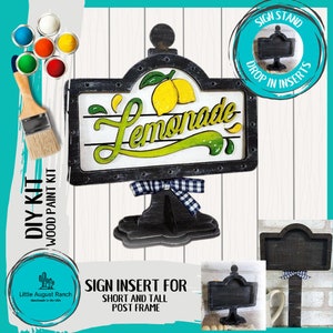 May include: DIY wood paint kit for a lemonade sign. The kit includes a black sign frame with a white background and the word "Lemonade" in green and yellow lettering. The sign is attached to a black stand with a black and white checkered bow. The kit also includes a smaller black sign frame with a white background. The sign frame is labeled "Sign Insert for Short and Tall Post Frame".