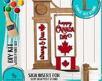 Może przedstawiać: Zestaw do samodzielnego montażu drewnianego znaku z kanadyjską flagą i tekstem "Happy Canada Day". Znak jest zaprojektowany do montażu na smukłym stojaku na znak lub na dużym stojaku o wymiarach 18,5 cala. Zestaw zawiera pojemniki z farbą w różnych kolorach.