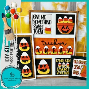 May include: DIY kit for a Halloween-themed wood sign with candy corn and pumpkin designs. The kit includes pre-cut wood shapes, paint, and instructions. The sign features the phrases "Give me something sweet to eat", "trick or treat", "Candy corn is my favorite vegetable", and "Old Fashioned 25¢ Bag".