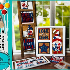 May include: A DIY wood paint kit featuring patriotic-themed wooden cutouts. The kit includes a wooden ladder with framed signs that read "Stars & Stripes" and "Land that I Love." Other signs say "Home of the Brave" and "Gnome of the USA."