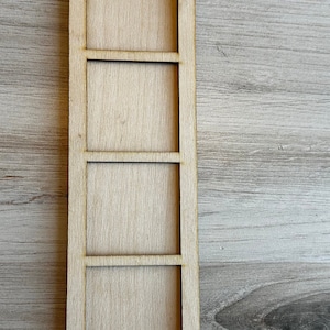 May include: A wooden shelf unit with four shelves. The shelf unit is made of light brown wood and has a simple design.