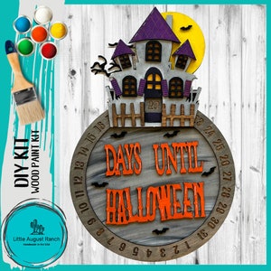 May include: A wooden Halloween countdown clock with a purple and gray haunted house on top. The clock is painted with a gray and black marbled design and has the numbers 1 to 31 around the edge. The words "Days Until Halloween" are written in orange on the clock. The clock is a DIY kit and comes with paint.