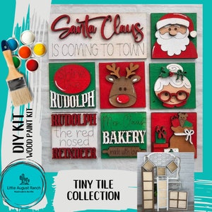 May include: A DIY wood paint kit featuring Christmas-themed tiny tiles. The kit includes tiles with phrases like "Santa Claus is Coming to Town" and images of Santa, Rudolph, and Mrs. Claus. Also included are paint colors and a paintbrush.