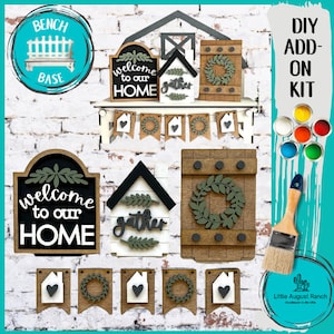 May include: DIY wood sign kit with a farmhouse theme. The kit includes a welcome sign, a gather sign, a wreath sign, and a banner with hearts and wreaths. The kit also includes paint and a paintbrush.
