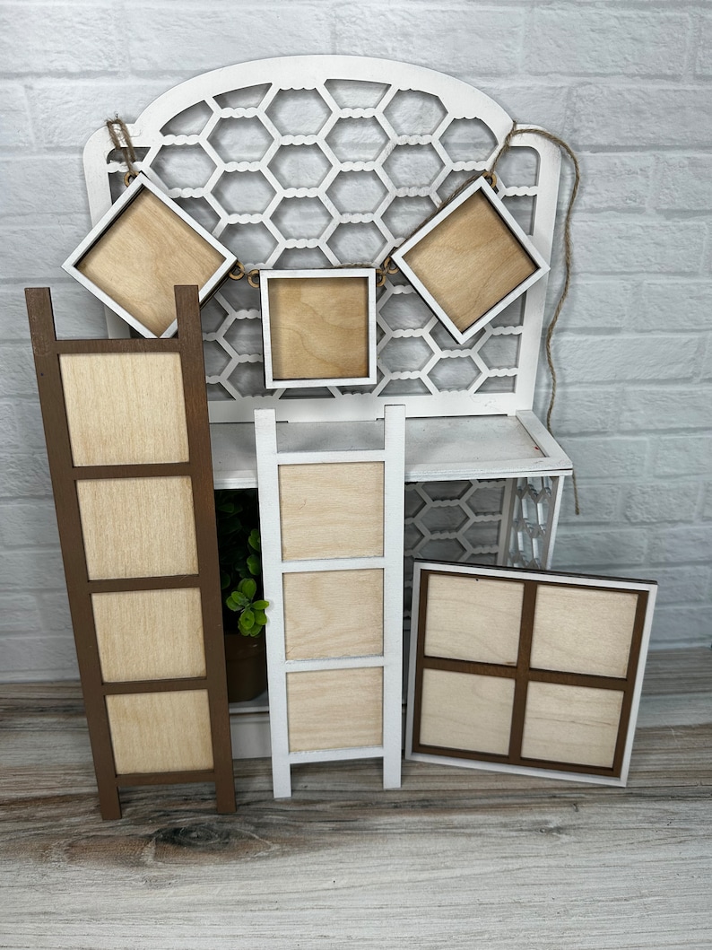 May include: A set of six unfinished wooden picture frames, including a ladder style frame, a four-panel frame, and four individual square frames. The frames are all made of natural wood and have a rustic look.