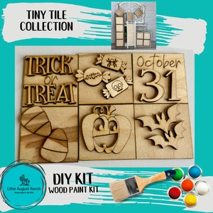 May include: A DIY wood paint kit with six wooden tiles featuring Halloween-themed designs. The tiles include "Trick or Treat", candy corn, a skull and crossbones, "October 31", a pumpkin, and bats. The kit includes paintbrushes and paint pots.