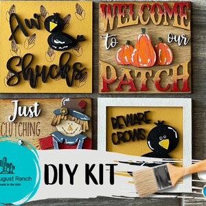 May include: DIY kit for creating four fall-themed wooden signs. The signs feature a scarecrow, crows, pumpkins, and corn. The kit includes paint, brushes, and stencils.