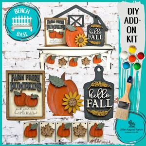May include: DIY wood craft kit featuring a farmhouse style sign with the text "Farm Fresh Pumpkins" and a pumpkin with a sunflower. The kit also includes a sign with the text "Hello Fall" and a banner with pumpkins and leaves. The kit comes with paints in various colors.