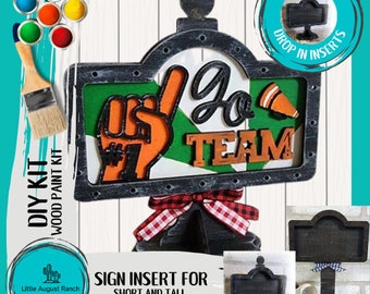 Puede incluir: Kit de letrero de madera DIY con un marco negro y un diseño verde, blanco y naranja. El letrero dice "Go Team" y presenta un puño en alto con un número uno en él. El kit incluye un soporte para letrero y un inserto de letrero en blanco.
