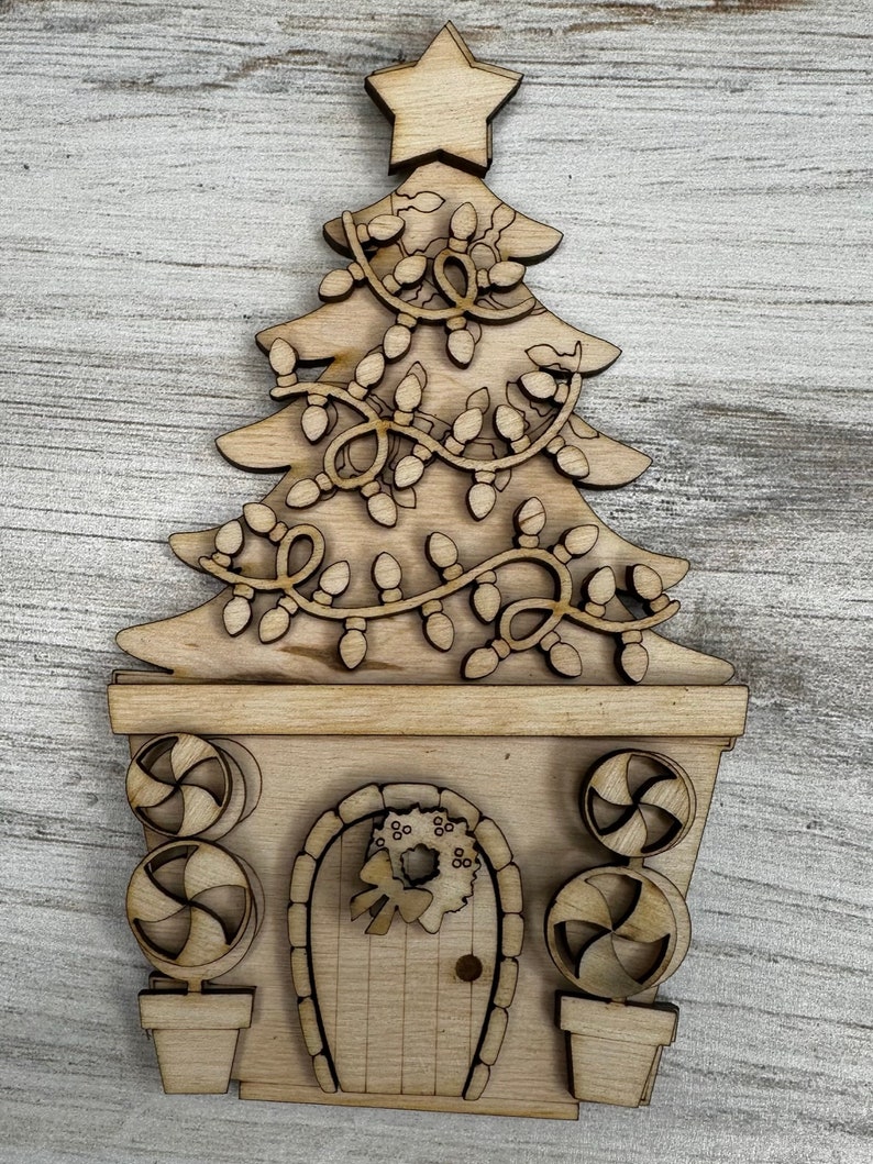 May include: A wooden Christmas tree ornament with a door and candy cane decorations. The tree is decorated with lights and a star on top.