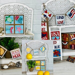 K&ouml;nnte beinhalten: Eine Sammlung von Holzschilden mit verschiedenen Sommer- und patriotischen Motiven. Die Schilder zeigen Bilder von Muscheln, einer Schildkr&ouml;te, einer Qualle, einem Seestern, einem Krebs, einer Zitrone, Feuerwerk und der amerikanischen Flagge. Die Schilder enthalten auch Text wie "Beach Mode", "Land That I Love", "USA", "Red White & Blue" und "1776".