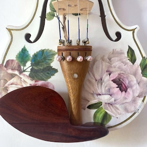 a violin with a floral design on the body and a wooden bow.
