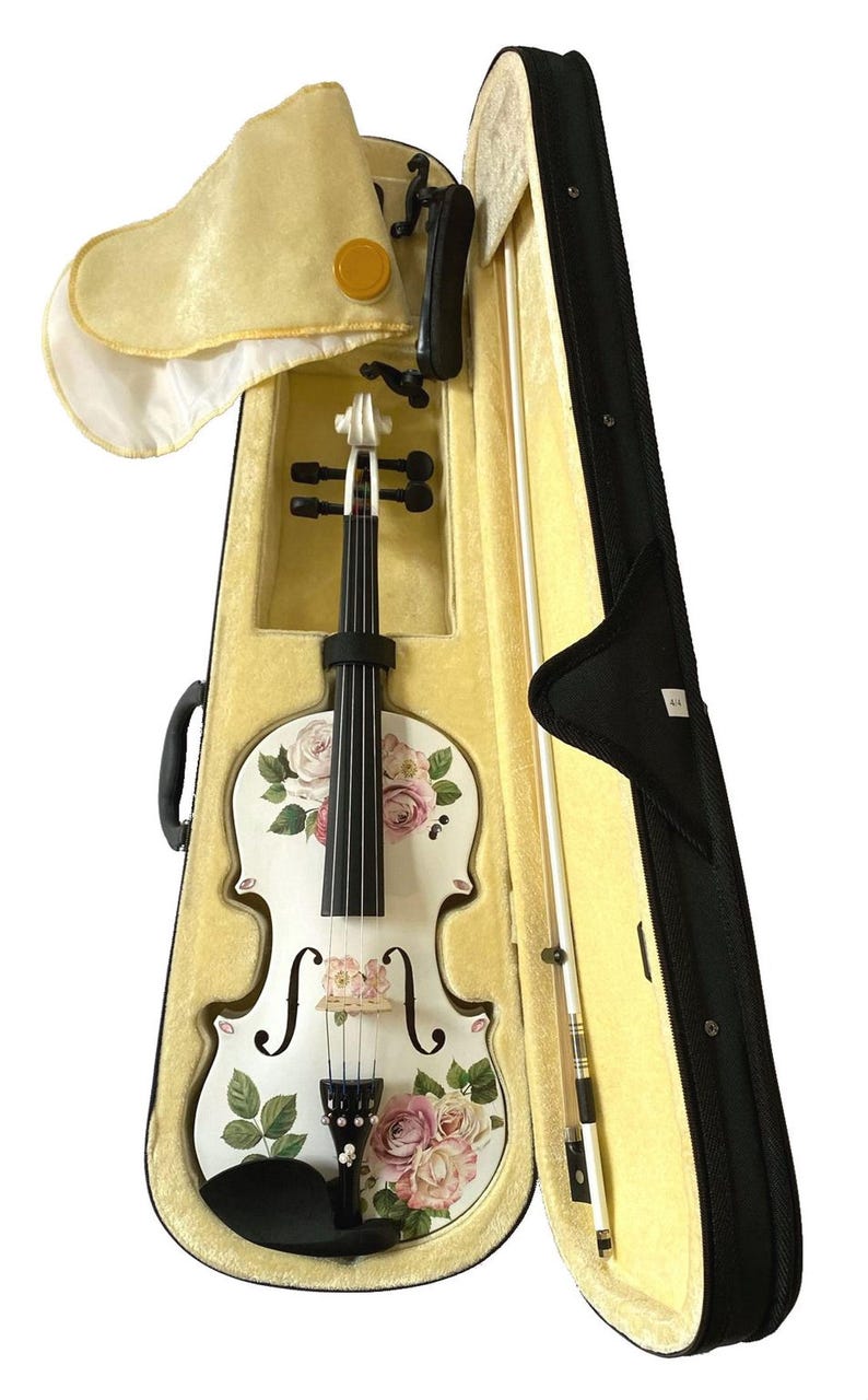 A white violin with a floral pattern on its body is displayed in a yellow violin case with a black handle.