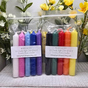 May include: Two clear plastic bags each containing five 4-inch chime candles in various colors. The left bag holds white, pink, light blue, dark blue, and purple candles. The right bag holds black, green, red, orange, and yellow candles.