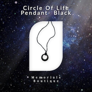 May include: Black circle of life pendant necklace on a white background. The pendant is a simple circle with a small gap in the top. The necklace is black and has a simple design. The background is a white rectangle with a rounded top and bottom. The text "Circle Of Life Pendant - Black" is above the necklace and the text "Memorials Boutique" is below the necklace.