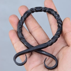 Fivela de cinto em forma de cruz de troll medieval forjada à mão em ferro torcido.