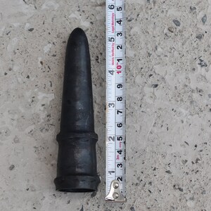 May include: A black rubber nozzle with a metal ring around the base. The nozzle is 5 inches long and is being measured with a tape measure.