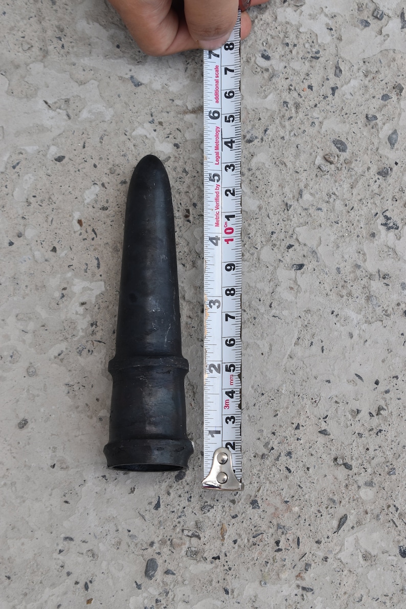May include: A black rubber nozzle with a metal ring around the base. The nozzle is 5 inches long and is being measured with a tape measure.