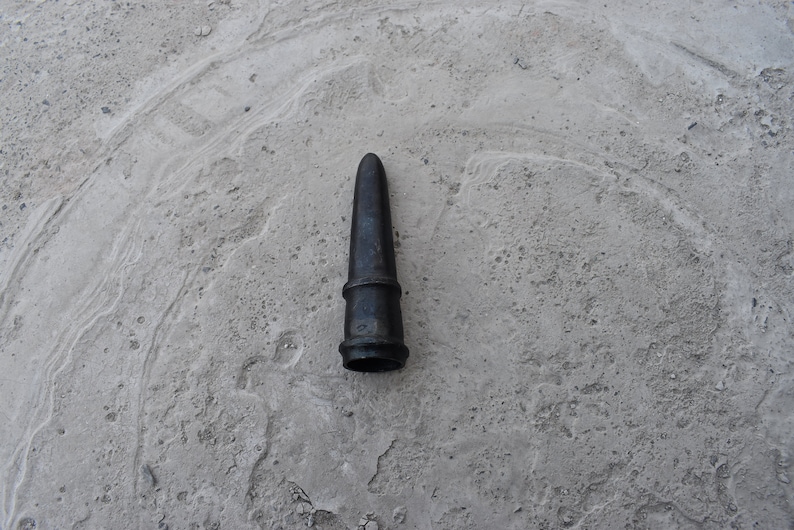 May include: A black metal nozzle with a pointed tip and a ribbed design.