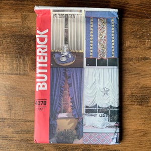 May include: A vintage Butterick pattern envelope showcasing curtain designs. The cover presents different curtain styles, including ruffled and patterned options, with a red vertical stripe on the left side that reads "BUTTERICK". The pattern number is 4370.
