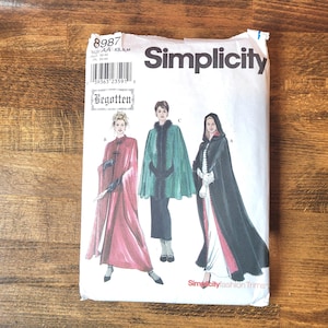 May include: A Simplicity sewing pattern envelope 8987 featuring illustrations of three different capes. The white paper envelope displays the brand name Simplicity, the pattern number 8987, and the Begotten label, showcasing designs for capes.