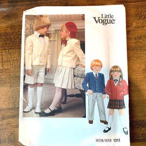 May include: A vintage Little Vogue sewing pattern with illustrations of children's formal outfits. The pattern shows designs for a cream-coloured double-breasted blazer with shorts, a pleated skirt, and a red blazer with a plaid skirt. Pattern number 1313.