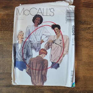 May include: McCall's sewing pattern for a jacket, size 8. The pattern shows three different styles of jackets, one with a plaid design, one with a brown design, and one with a white design.
