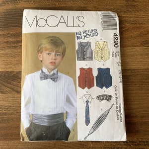 May include: McCall's sewing pattern for a boy's formal attire, showing a young boy in a tuxedo. The pattern includes options for waistcoats, ties, and cummerbunds. The package is labelled with the number 4290 and size range (10-12-14).
