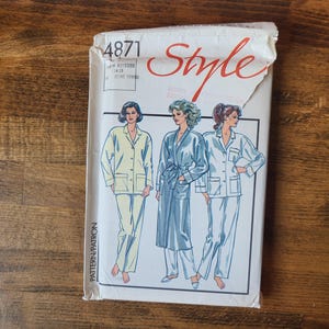 May include: A sewing pattern envelope with the number 4871 and the word "Style" printed on the front. The envelope features illustrations of three women wearing different styles of pajamas.