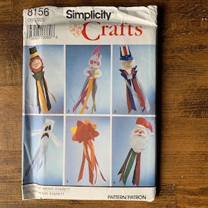 May include: Simplicity Crafts pattern featuring six whimsical craft designs. The designs include a scarecrow, a bunny, Uncle Sam, a ghost, a starburst, and Santa Claus. The pattern is one size.