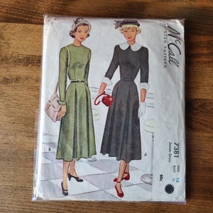 May include: Vintage McCall's sewing pattern for a junior dress. The pattern is for size 15, bust 32. The pattern shows two women wearing the dress, one in green and one in black.