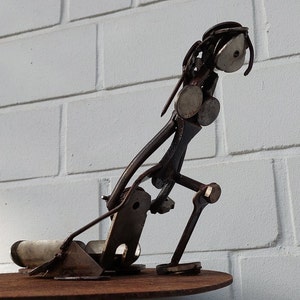 Zwaar werk 1, schrootkunst, sculptuur gemaakt van schroot, schrootkunst, uniek, hard werken, ijzeren figuur, vrouwenfiguur, vrouw die kar trekt