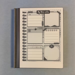 Może przedstawiać: Czarno-biały czytnik e-booków z okładką w postaci zeszytu w spirali. Okładka ma tytuł "My Mini Notes" i jest podzielona na cztery sekcje z różnymi ozdobnymi ramkami. Każda sekcja ma puste miejsce do pisania.