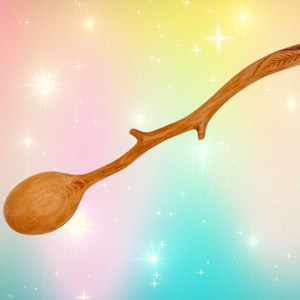 May include: A wooden spoon with a unique branch-like handle. The handle is carved with a leaf design. The spoon is made of natural wood and has a warm brown color.