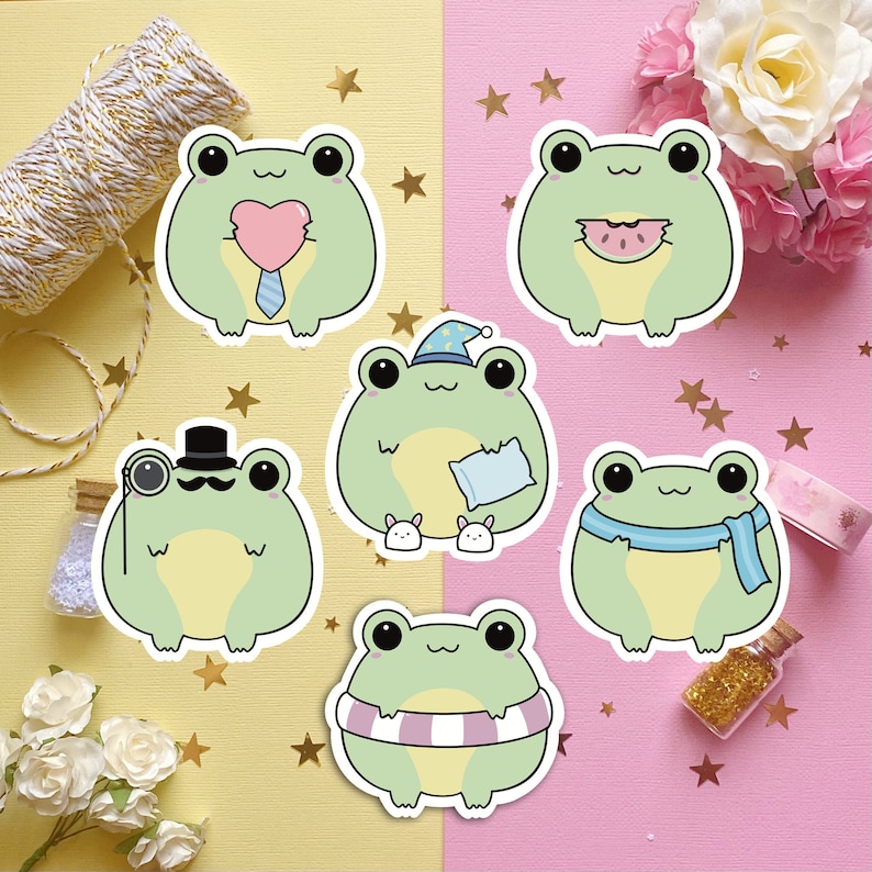 May include: Six different frog stickers with various expressions and accessories. The frogs are green with white eyes and are wearing items like a top hat, a scarf, a sleep mask, a heart, and a watermelon slice.