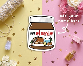 May include: A sticker of a brown jar of Nutella with the name "Melanie" written on it. The sticker is on a pink and yellow background with gold stars.