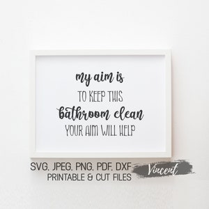 May include: A white framed print with black text that reads "my aim is to keep this bathroom clean your aim will help". The print is on a white background and has the words "SVG, JPEG, PNG, PDF, DXF Printable & Cut Files Vincent" at the bottom.
