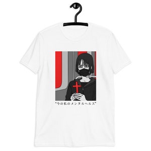 May include: A white short-sleeve t-shirt featuring a graphic print of a person with short black hair wearing a black face mask and a black hoodie. The person holds a red cross. The background is red and gray. Text reads: 今の私のメンタルヘルス.