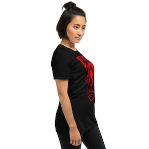 May include: A black t-shirt with a red graphic print of a woman's face. The graphic is stylized and abstract.