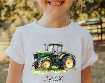 May include: White t-shirt featuring a green tractor with yellow wheels. The word "JACK" is printed below the tractor. The word "WHITE" is printed at the bottom right corner of the shirt.