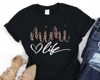May include: Black t-shirt with a leopard print "mama" design and the text "life" in white script with a heart.