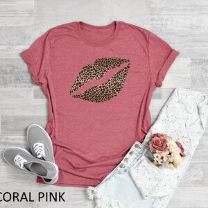 May include: Coral pink t-shirt with a leopard print lip design.