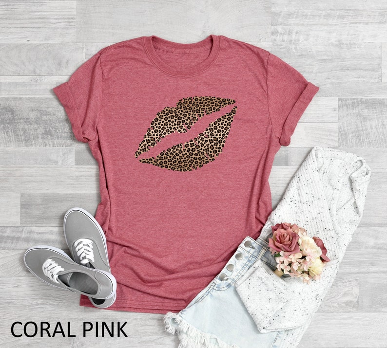 May include: Coral pink t-shirt with a leopard print lip design.