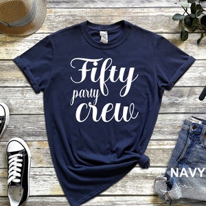 May include: Navy blue t-shirt with white text that reads "Fifty party crew".