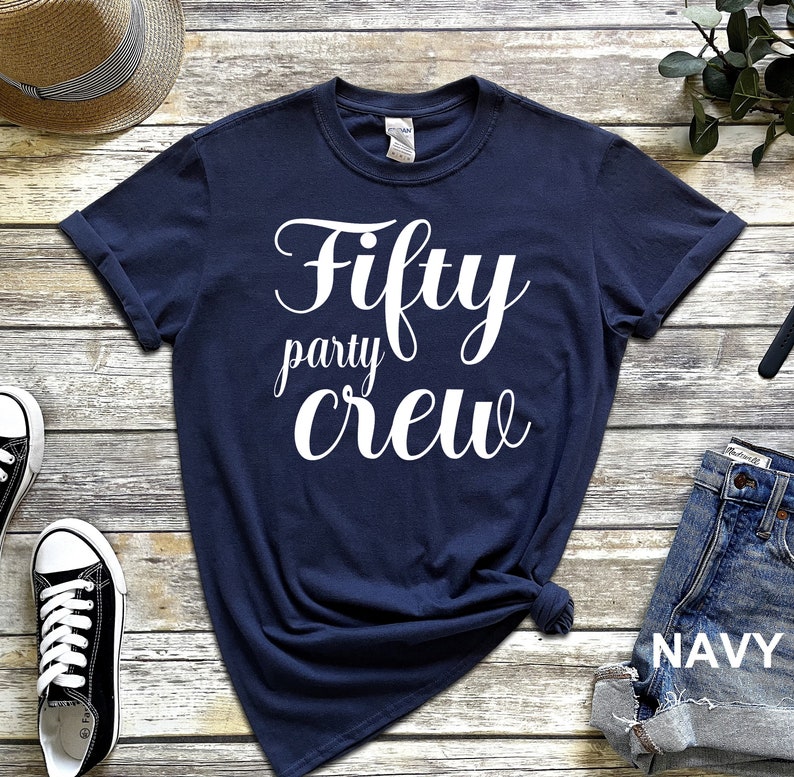 May include: Navy blue t-shirt with white text that reads "Fifty party crew".