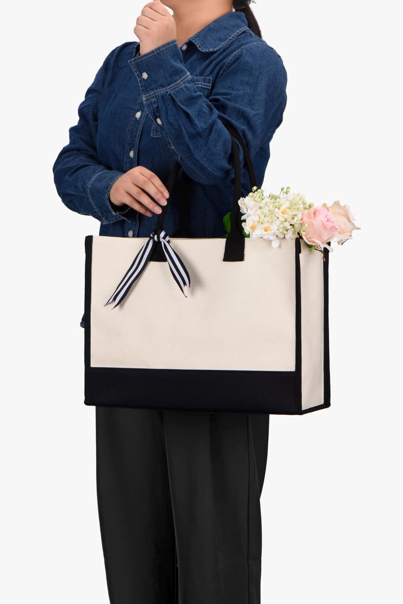 a woman holding a white and black bag